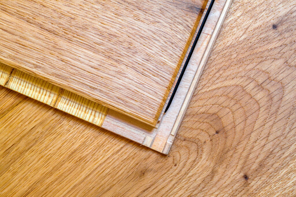 Brown wooden parquet floor planks installation , close up. Carpentry concept.